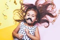 Cute little girl in funny glasses with paper mustache. Royalty Free Stock Photo