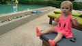 Cute little girl gesticulates near pool