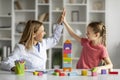 Little Girl Giving High Five To Child Development Specialist, Celebrating Successful Therapy