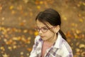 little girl in glasses and plaid shirt in the autumn park Royalty Free Stock Photo