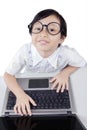 Cute little girl with glasses using laptop Royalty Free Stock Photo