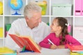 Cute little girl with grandfather doing homework Royalty Free Stock Photo