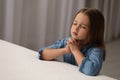 Cute little girl with hands clasped together saying bedtime prayer in bedroom. Space for text Royalty Free Stock Photo