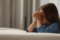 Cute little girl with hands clasped together saying bedtime prayer in bedroom. Space for text Royalty Free Stock Photo