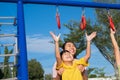 Cute little girl hanging bars in the playground. Happy little Asian child having fun on playground, climbing bars in park. Little Royalty Free Stock Photo