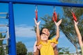 Cute little girl hanging bars in the playground. Happy little Asian child having fun on playground, climbing bars in park. Little Royalty Free Stock Photo