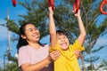 Cute little girl hanging bars in the playground. Happy little Asian child having fun on playground, climbing bars in park. Little Royalty Free Stock Photo