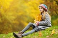 Cute little girl having fun on beautiful autumn day. Happy child playing in autumn park. Kid gathering yellow fall foliage. Royalty Free Stock Photo