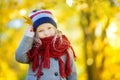 Cute little girl having fun on beautiful autumn day. Happy child playing in autumn park. Kid gathering yellow fall foliage. Royalty Free Stock Photo