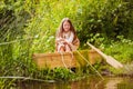 Cute little girl having fun in a boat by a river