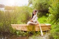 Cute little girl having fun in a boat by a river