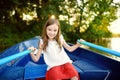 Cute little girl having fun in a boat by a river Royalty Free Stock Photo