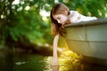 Cute little girl having fun in a boat by a river Royalty Free Stock Photo