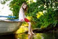 Cute little girl having fun in a boat by a river Royalty Free Stock Photo