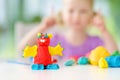 Cute little girl having fun with colorful modeling clay at a daycare. Creative kid molding at home. Royalty Free Stock Photo