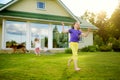 Cute little girl having fun on a grass on the backyard on sunny summer evening Royalty Free Stock Photo