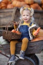 Cute little girl having fun with huge pumpkins on a pumpkin patch. Royalty Free Stock Photo