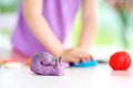 Cute little girl having fun with modeling clay at a daycare. Creative kid molding at home. Royalty Free Stock Photo