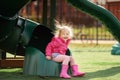 Cute little girl having fun on outdoor playground. Child on plastic slide