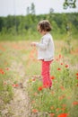 Cute little girl having fun in a poppy field Royalty Free Stock Photo