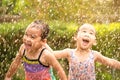 Cute little girl having fun in rainy at backyard. Children enjoy outdoor activities on hot summer days Royalty Free Stock Photo