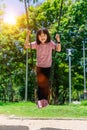 Cute little girl having fun on a swing in beautiful summer garden. Child girl playing on outdoor playground in park. Active summer Royalty Free Stock Photo