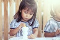 Cute little girl having fun to paint on stucco doll Royalty Free Stock Photo