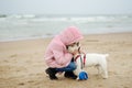 Cute little girl having fun at winter beach on cold winter day. Kids playing by the ocean Royalty Free Stock Photo