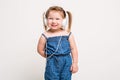 Cute little girl in headphones listening to music using a tablet and smiling on white background Royalty Free Stock Photo