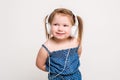 Cute little girl in headphones listening to music using a tablet and smiling on white background Royalty Free Stock Photo