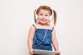 Cute little girl in headphones listening to music using a tablet and smiling on white background Royalty Free Stock Photo