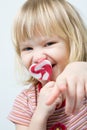 Cute little girl with a heart shape lollipop Royalty Free Stock Photo