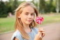 Cute little girl with heart-shaped lollipop outdoors Royalty Free Stock Photo