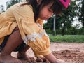 Cute little girl in helmets are playing with sand in park on a sunny summer day, taking a break after cycling practice. develop