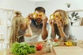 Cute little girl and her beautiful parents are cutting vegetables in kitchen at home Royalty Free Stock Photo