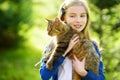 Cute little girl with her cat on sunny autumn day. Adorable child holding het pet kitty. Royalty Free Stock Photo