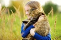 Cute little girl with her cat on sunny autumn day. Adorable child holding het pet kitty. Royalty Free Stock Photo