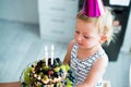 Cute little girl with her fruit birthday cake with two candles Royalty Free Stock Photo