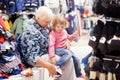 Cute little girl and her grandmother choosing clothes in the shop. Royalty Free Stock Photo