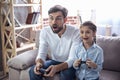 Father and daughter. Cute little girl and her handsome father are playing game console Royalty Free Stock Photo