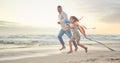 Cute little girl and her mixed race dad flying a kite on the beach. Adorable daughter and her handsome father running Royalty Free Stock Photo