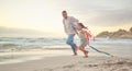 Cute little girl and her mixed race dad flying a kite on the beach. Adorable daughter and her handsome father running Royalty Free Stock Photo