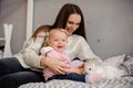 Cute little girl and her mom playing with white rabbit Royalty Free Stock Photo