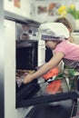 Cute little girl with her mother baking cookies in oven Royalty Free Stock Photo