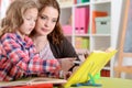 Cute little girl with her mother doing homework Royalty Free Stock Photo