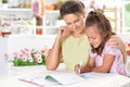 Cute little girl with her mother doing homework Royalty Free Stock Photo