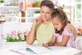 Cute little girl with her mother doing homework Royalty Free Stock Photo