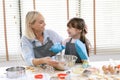 Cute little girl and her mother preparing the dough in the kitchen at home.Happy family and people concept.Mother`s day Royalty Free Stock Photo