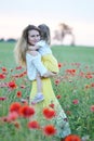 Cute little girl with her mother walking in the field with poppies flowers Royalty Free Stock Photo