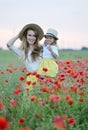 Cute little girl with her mother walking in the field with poppies flowers Royalty Free Stock Photo